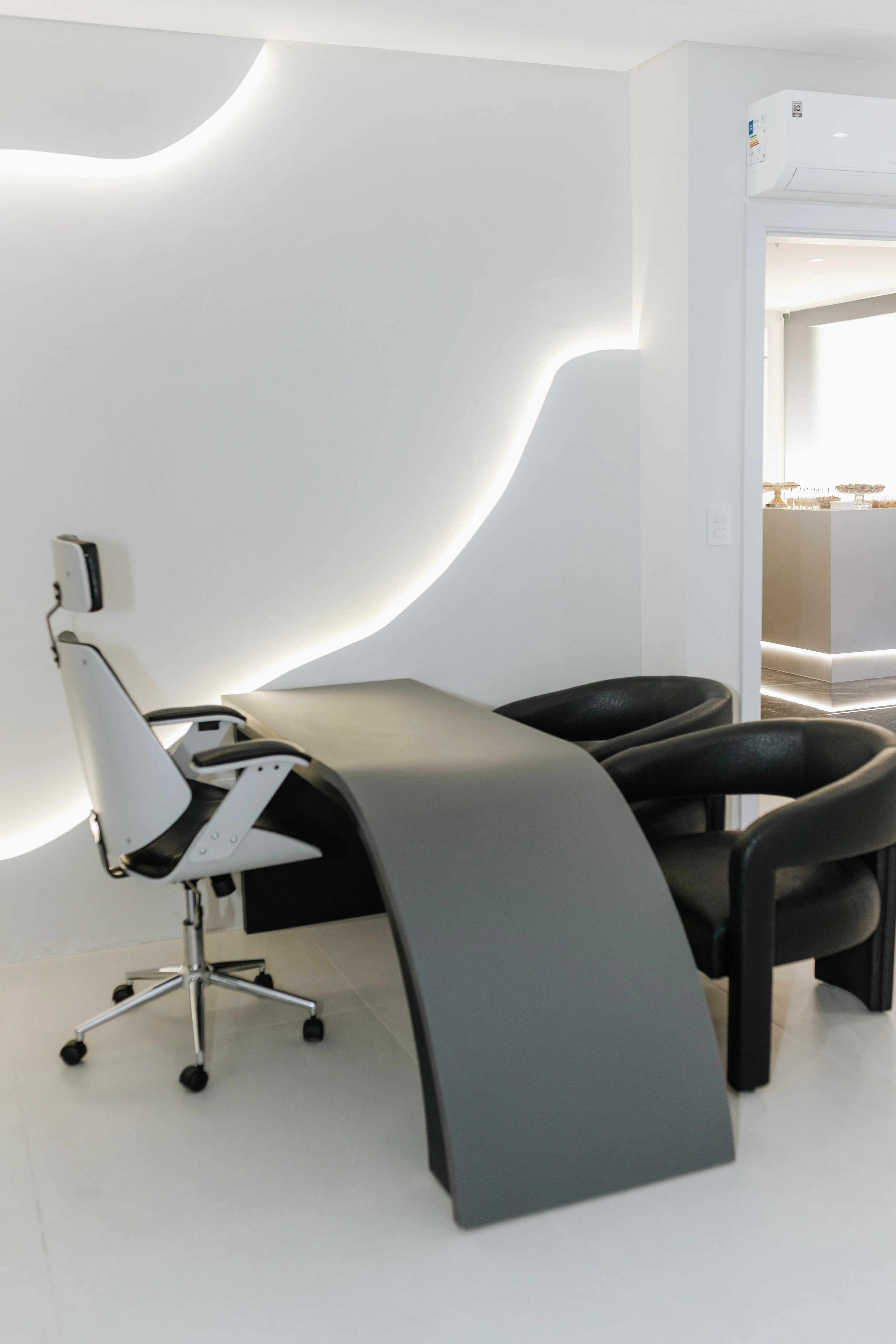 Mesa de consulta com cadeiras e iluminação indireta na parede