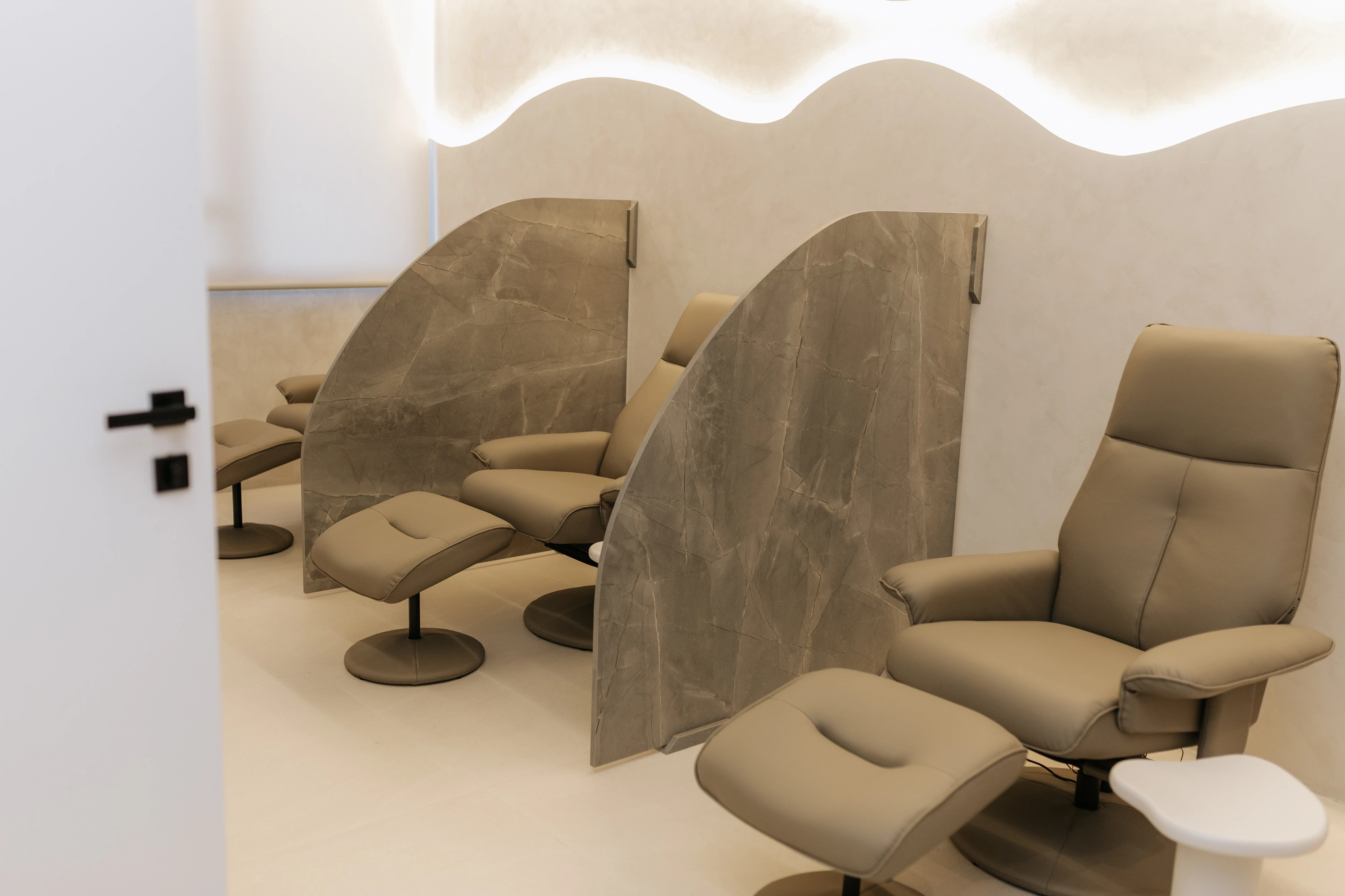Sala de repouso com poltronas reclináveis e divisórias individuais
